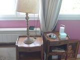 une petite table sur laquelle est posée une lampe, à côté d'un lit