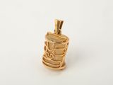 a close up of a gold pendant on a white surface