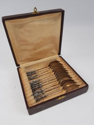 six cuillères dans un coffret en bois contenant de l'argenterie