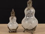 two glass vases sitting on top of a table next to each other