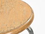 a close up of a wooden stool with metal legs
