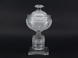 a clear glass vase with a bird on top of it