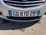 a silver car with a blue license plate on it