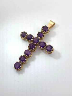a gold cross with purple stones on a white background