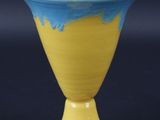 un vase jaune et bleu sur fond noir