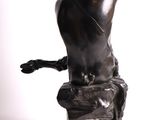 statue of a woman sitting on a rock with her hands on her head