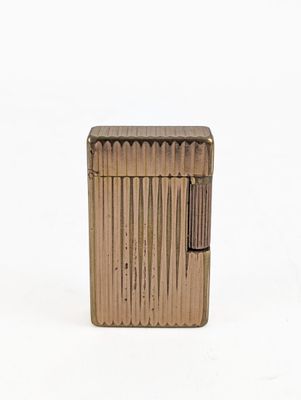 an image of a gold lighter sitting on top of a white surface