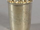 a silver cup with a bird design on it
