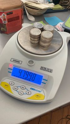 une balance sur laquelle est posée une pile de pièces