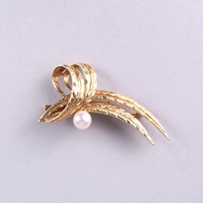 une broche en or sertie d'une perle