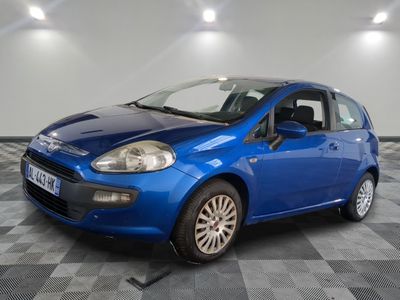 la petite voiture bleue est garée sur un sol en damier
