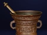 bronze mortar and pestula on a dark background with a blue background