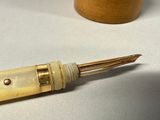 a pen that is sitting on a table next to a cup