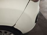 the car is white and has a dent in it
