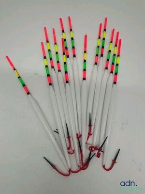 several different colored fishing rods are lined up on a white surface
