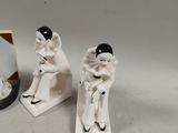 two figurines of a woman sitting on a bench