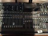 une photo montrant une grande console de mixage posée sur une table en bois