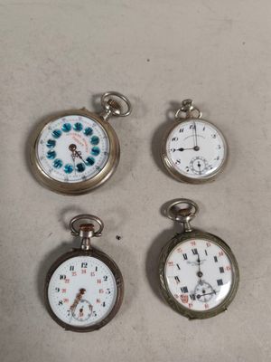 four different types of pocket watches sitting on top of a table