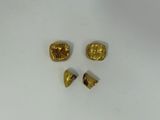 three pieces of gold colored metal on a white surface