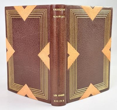an old book with a brown cover sitting on top of a white table