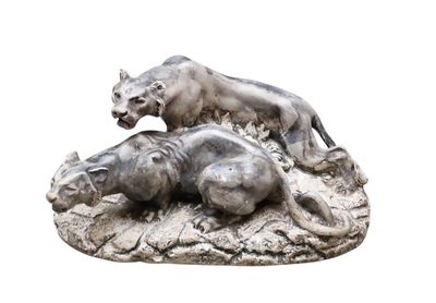 une statue représentant un lion et un hippopote, allongés sur un rocher
