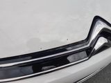 the front end of a white car with a black trim