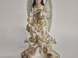 figurine of an angel holding a bird on a white background
