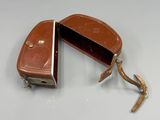 un étui en cuir marron contenant une paire de ciseaux
