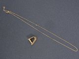a gold necklace with a triangle and a small triangle on it