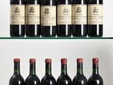several bottles of wine are lined up on a glass shelf