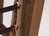 a close up of a wooden chair with a brown seat and back