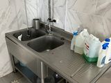 un évier avec un robinet et deux bouteilles d'eau posées sur le plan de travail