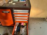 une armoire à outils orange dont le tiroir est rempli d'objets divers