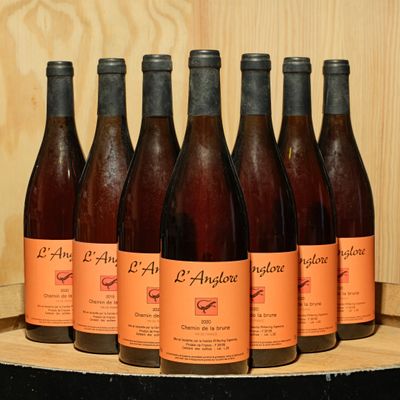 six bottles of wine are lined up on a wooden shelf