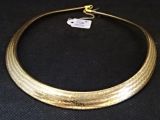 gros plan d'un collier en or sur une surface noire