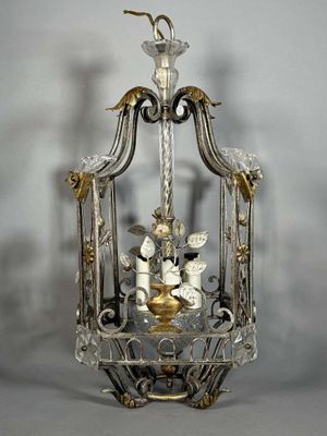 une cage à oiseaux en argent et en or, avec un oiseau à l'intérieur