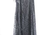 black lace dress hanging on a hanger against a white wall