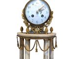 une horloge posée sur un socle et entourée de chaînes