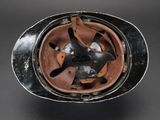 an old helmet is sitting on top of a black table