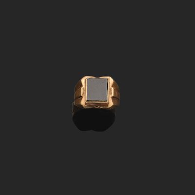 une bague en or 18 carats ornée d'une pierre carrée sertie au centre