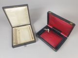 two open boxes with a ring inside of them on a white surface
