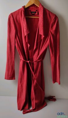 Une image représentant une robe rouge est suspendue à un cintre.