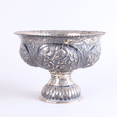a silver bowl that is sitting on a white surface