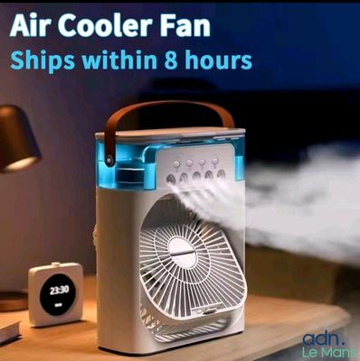 an air cooler fan sitting on top of a table next to a clock