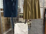 two skirts hanging on a wire rack in a room