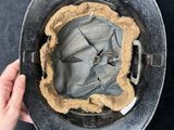 an overhead view of a person ' s hand holding a metal pan with a pie crust in it