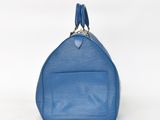 a blue louis vuitton bag on a white background