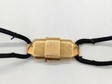 une photo d'un bracelet plaqué or avec un cordon noir