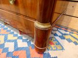 a wooden chest of drawers with brass handles on it