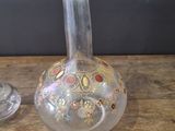 a glass vase and a wine glass sitting on a table